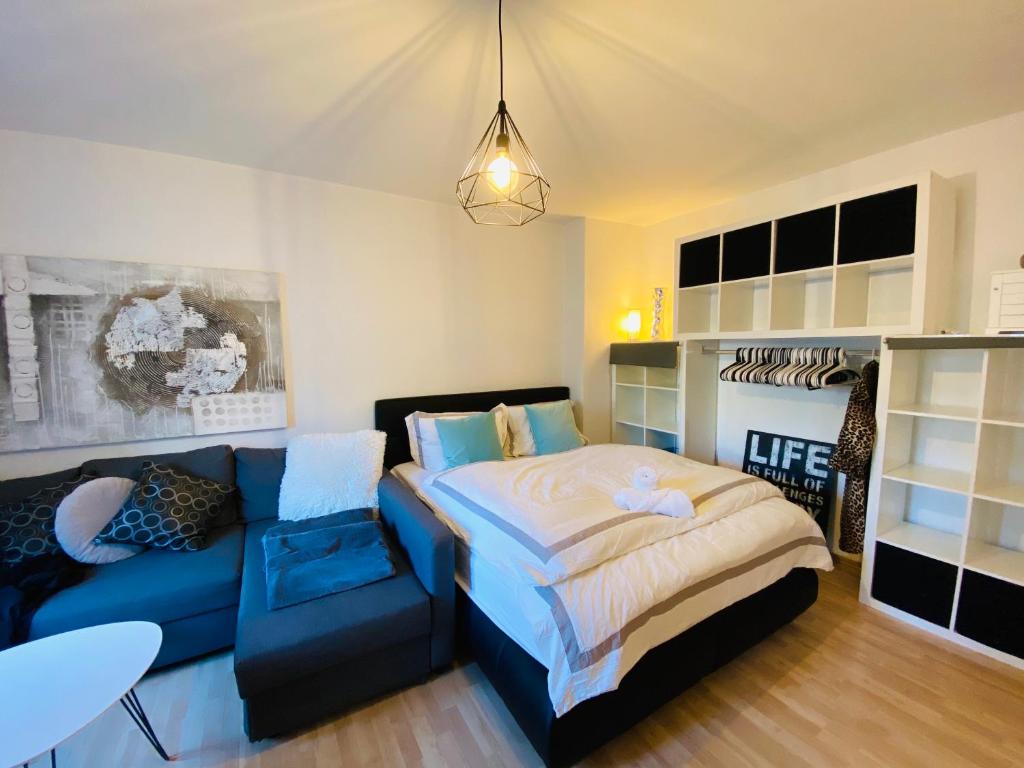 um quarto com uma cama e um sofá azul em Exclusive Maxvorstadt Studio em Munique