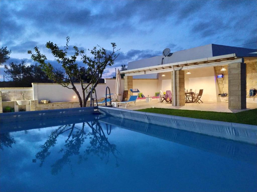 una casa con piscina frente a una casa en Pajara Fazzadio en Lido Marini
