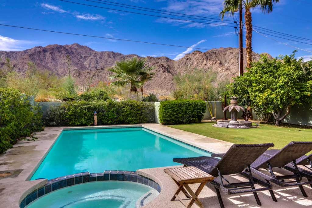 een zwembad met 2 stoelen en een gazon met bergen bij La Quinta Vacation Pool Home in La Quinta