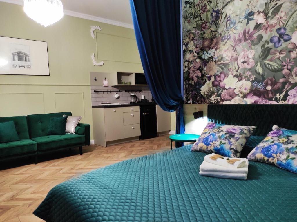 1 dormitorio con 1 cama con colcha verde en Petite Visite No 16 Apartment, en Toruń