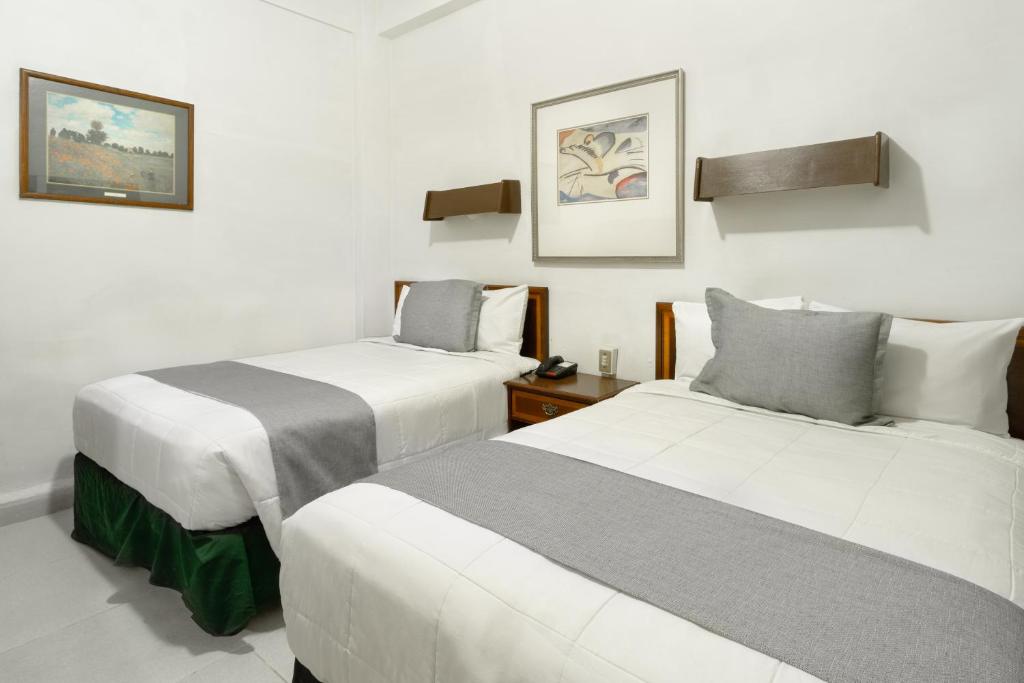 dos camas sentadas una al lado de la otra en una habitación en Hotel Premier Saltillo Coahuila, en Saltillo