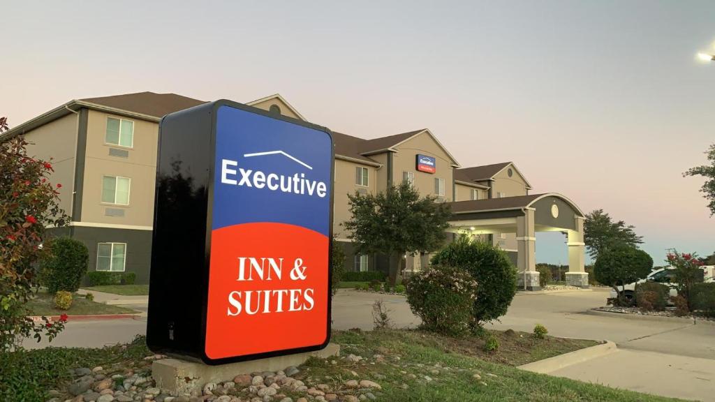 un panneau indiquant une auberge et des suites devant une maison dans l'établissement Executive Inn & Suites, à Marlin