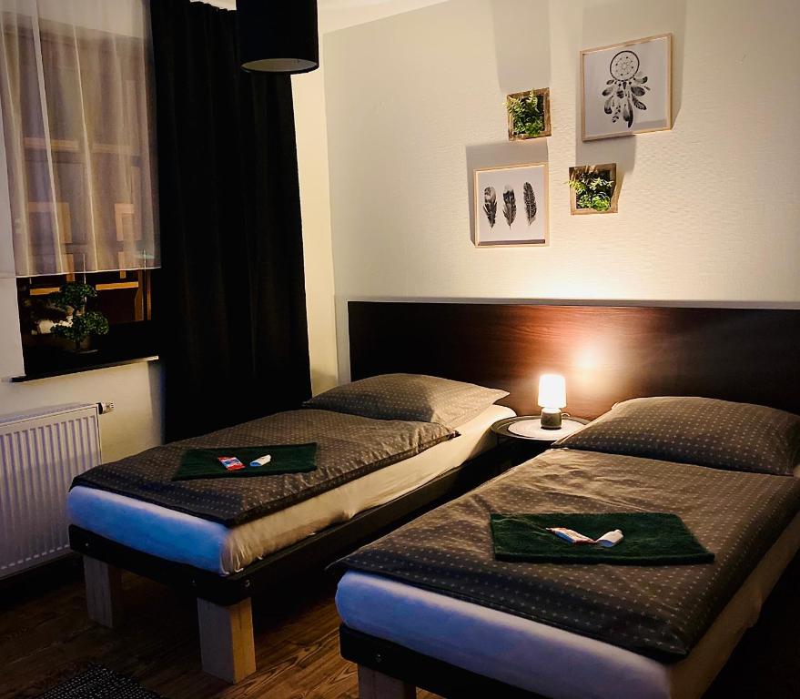 a hotel room with two beds and a table with a candle at Caffe Boulevard Penzion in Waldsassen