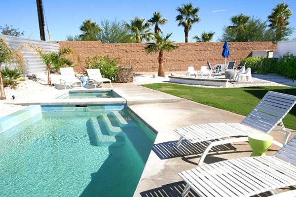 una piscina con tumbonas y una piscina en Poolside Modern Wexler Permit# 1261 en Palm Springs