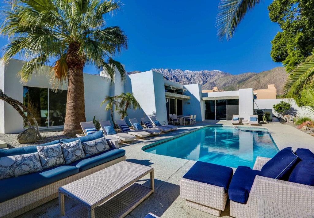 a villa with a swimming pool and palm trees at Plush Pad Palm Springs Permit# 2937 in Palm Springs