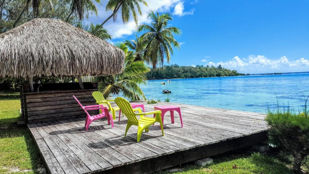 four chairs and a table on a dock next to the water at MOOREA - Villa Tereva Nui in Haapiti