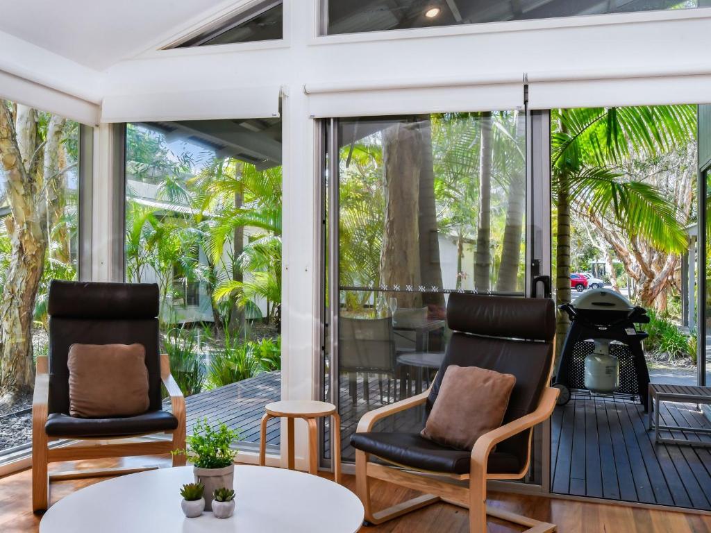 a room with two chairs and a table on a porch at Mobys Beach house 11 in Boomerang Beach