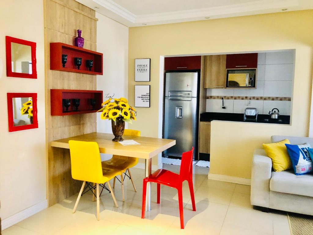 a kitchen and dining room with a table and chairs at Flat Blumenau Vila Nova in Blumenau