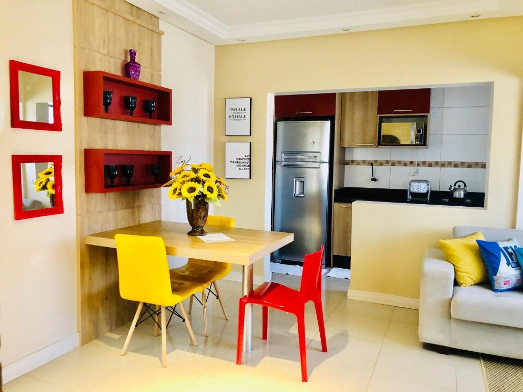 uma cozinha e sala de jantar com mesa e cadeiras em Flat Blumenau Vila Nova em Blumenau