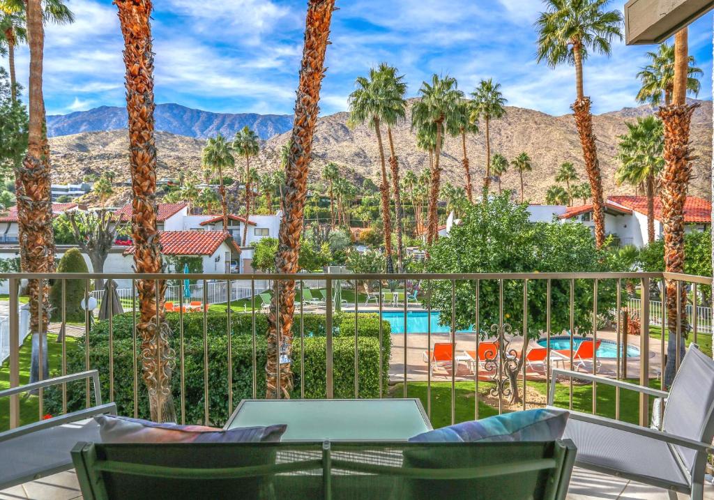 a balcony with palm trees and a view of a pool at Mountain View Modern Condo Permit# 4340 in Palm Springs