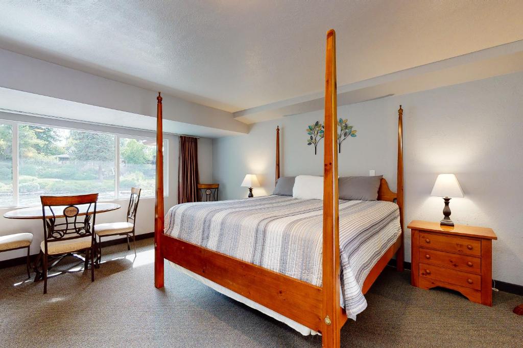 a bedroom with a bed and a table and a window at Deschutes Riverside Escape in Bend