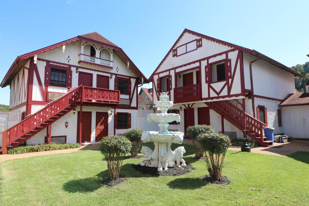 a house with a fountain in front of a building at Alpine Village Inn in Helen