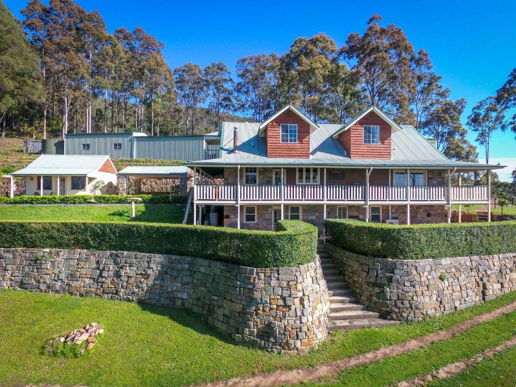 a large house with a stone wall at Bimbadeen Mountain Retreat in Mount View