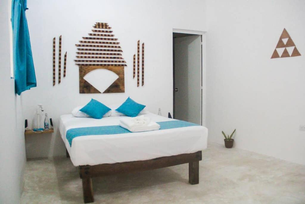 1 dormitorio con 1 cama con almohadas azules en M&M Apartments Holbox en Holbox Island