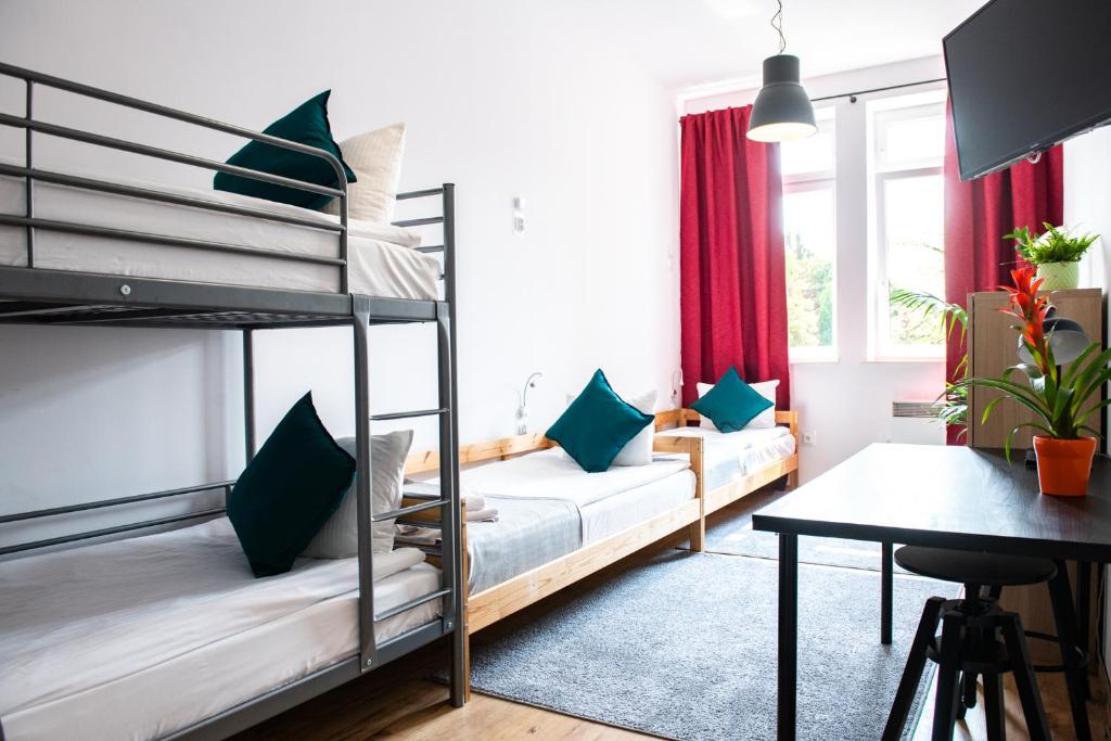 a bedroom with two bunk beds and a desk at Gdańsk Hostel in Gdańsk