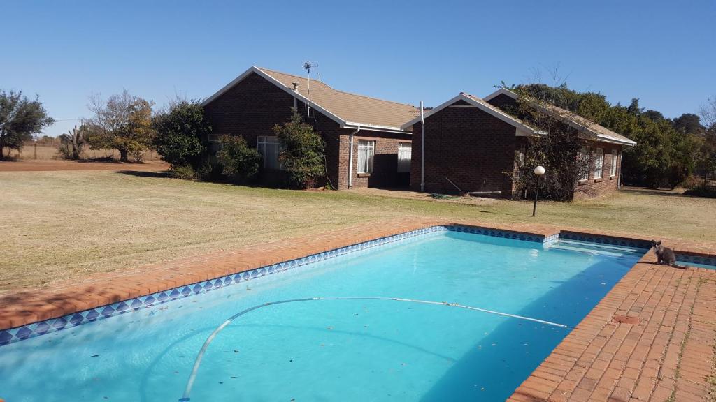 una piscina frente a una casa en House, Cottage and Contractors Manor, en Meyerton