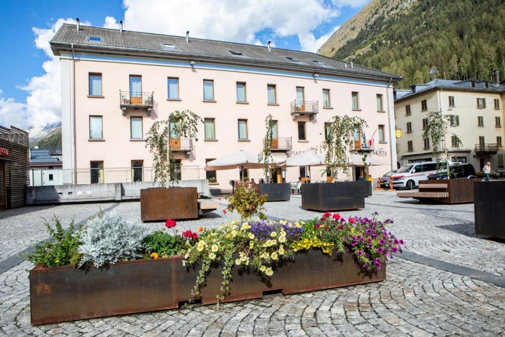 Ein Gebäude mit einem Blumenstrauß davor. in der Unterkunft BB Garni Motta in Airolo