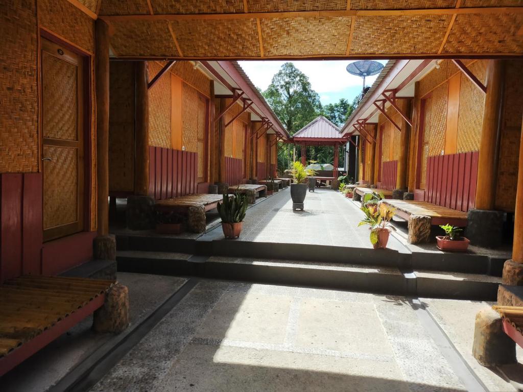 un corridoio di un edificio con panche e piante in vaso di Gosyen Efata Toraja Hotel a Makale