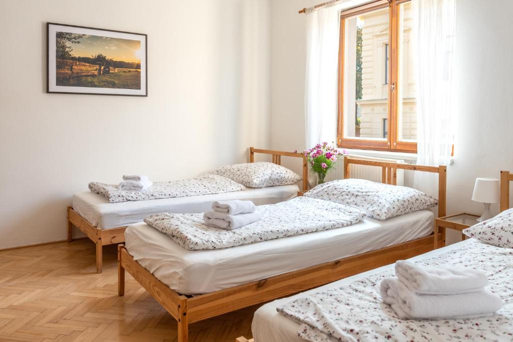 a group of four beds in a room at Dobrý Kanec - Hostinec in Mělník