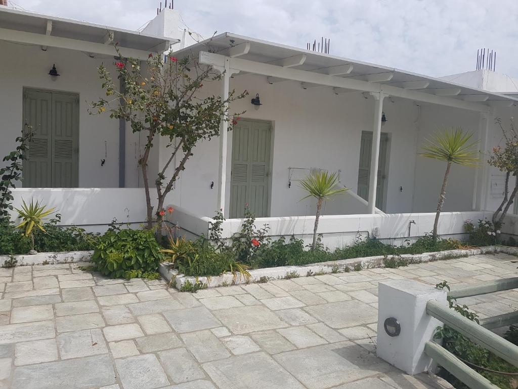 uma casa branca com plantas à frente em ISALOS ROOMS ON THE BEACH em Serifos Chora