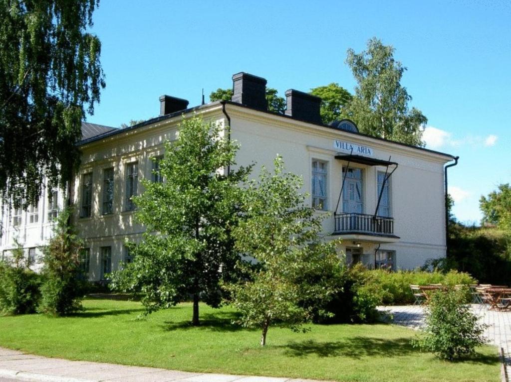 ein weißes Gebäude mit einem Baum davor in der Unterkunft Boutique Hotel Willa Aria in Savonlinna