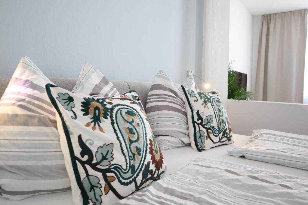 a large bed with white pillows and pillows at Anastacia Premium Apartment FREE Parking & Self Check-in in Graz