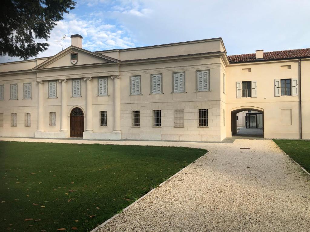a large white building with a grass yard at Villa Cantoni Marca in Sabbioneta