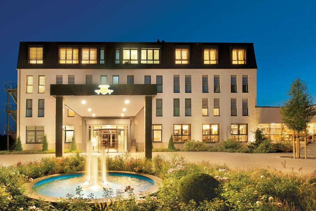 a building with a fountain in front of it at Landhotel Beck in Kupferzell