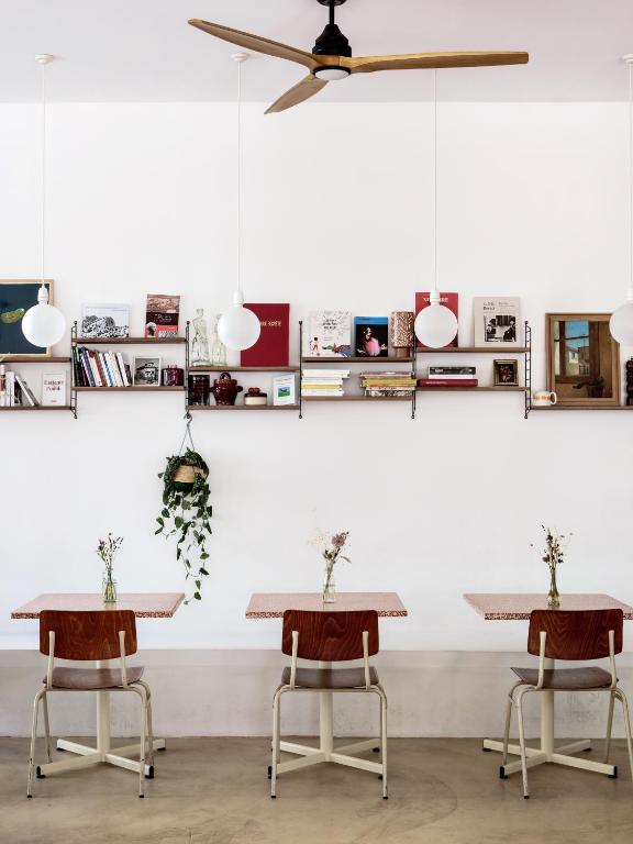 two tables and two chairs in front of a wall at Hôtel Voltaire in Arles