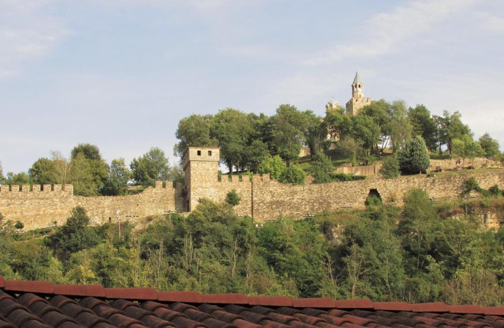 una pared de piedra con un castillo en una colina en Home with the veranda (B&B) free parking en Veliko Tŭrnovo