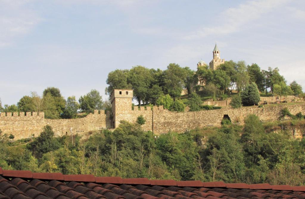 a stone wall with a castle on a hill at Home with the veranda (B&B) free parking in Veliko Tŭrnovo