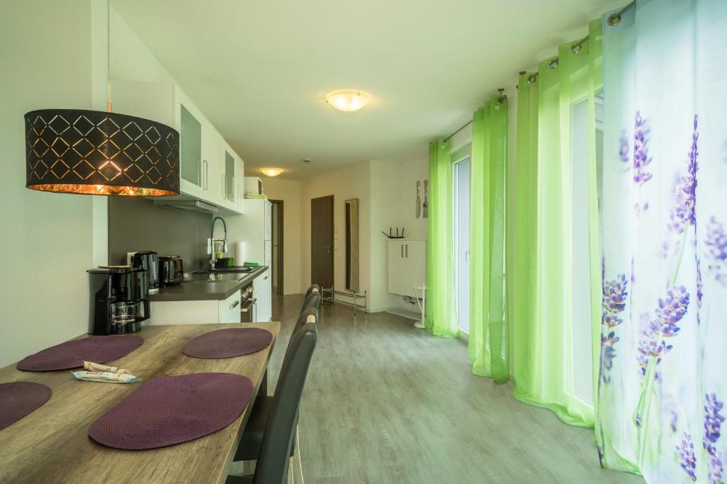 a kitchen and dining room with green walls and a table at Ferienwohnung Lavendel in Sipplingen
