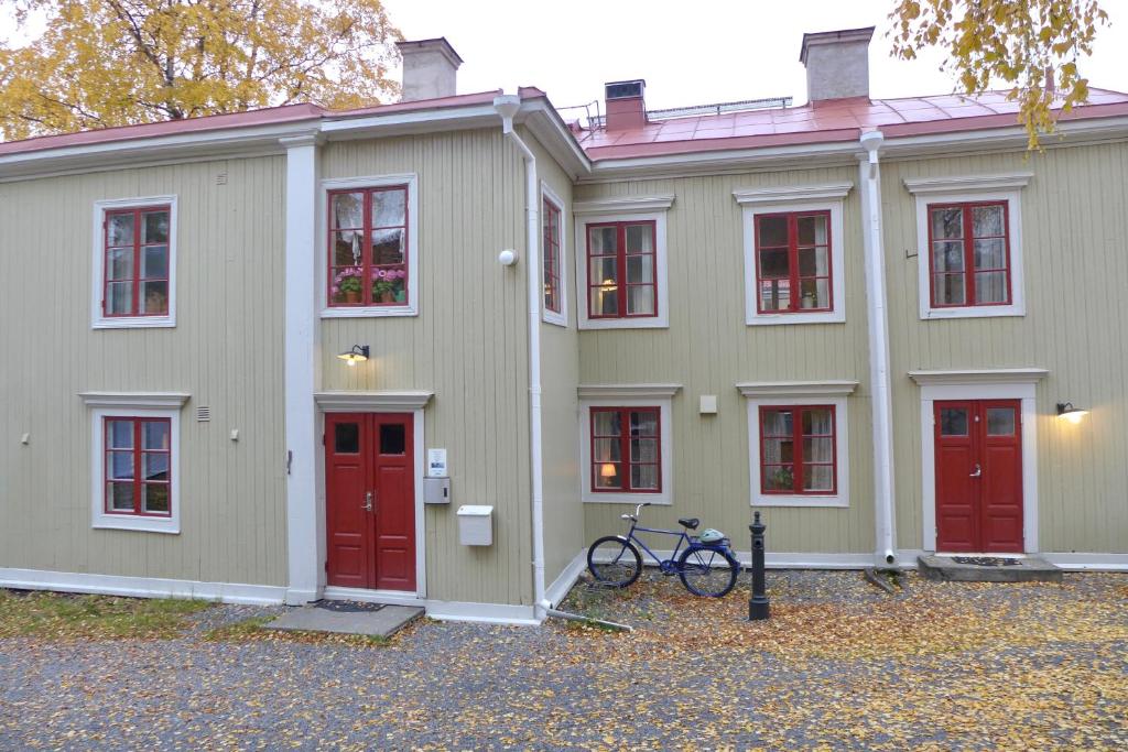 um edifício com portas vermelhas e uma bicicleta estacionada em frente em Prästgatanett Apartments em Östersund