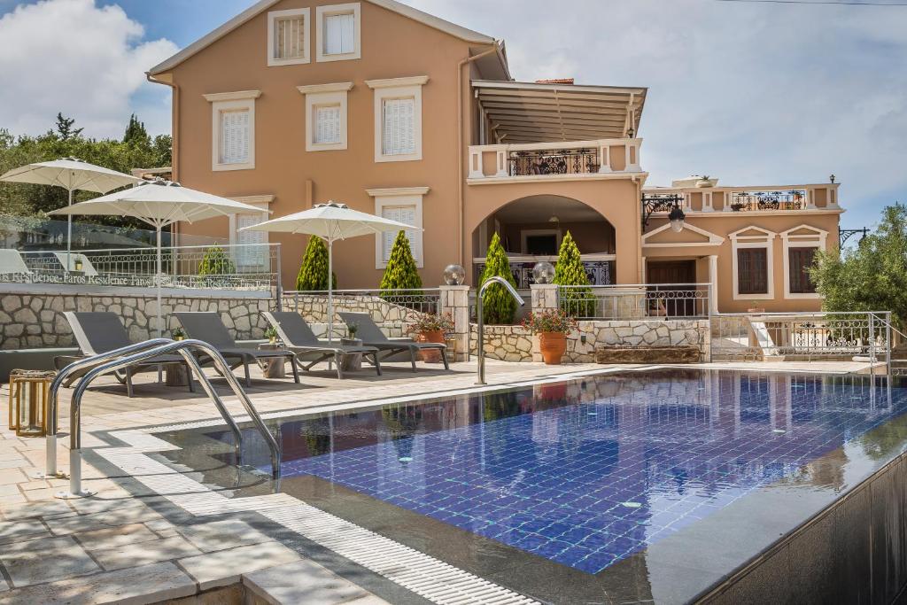 a villa with a swimming pool in front of a house at Faros Residence Adults Only in Fiskardho