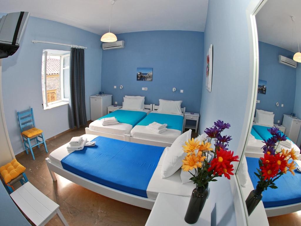 a blue bedroom with a bed and a blue wall at Theano Guesthouse in Hydra