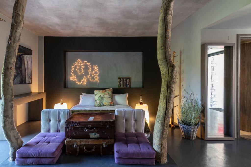 a bedroom with a bed with purple accents and trees at Oniropetra Boutique Hotel in Karpenisi