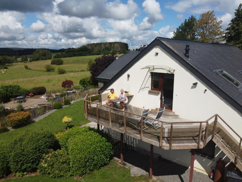 two men sitting on the deck of a house at la Nouchettière in La Roche-en-Ardenne