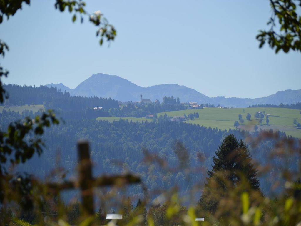 una cruz en la cima de una colina con montañas en el fondo en Alex Bergblick, en Scheidegg