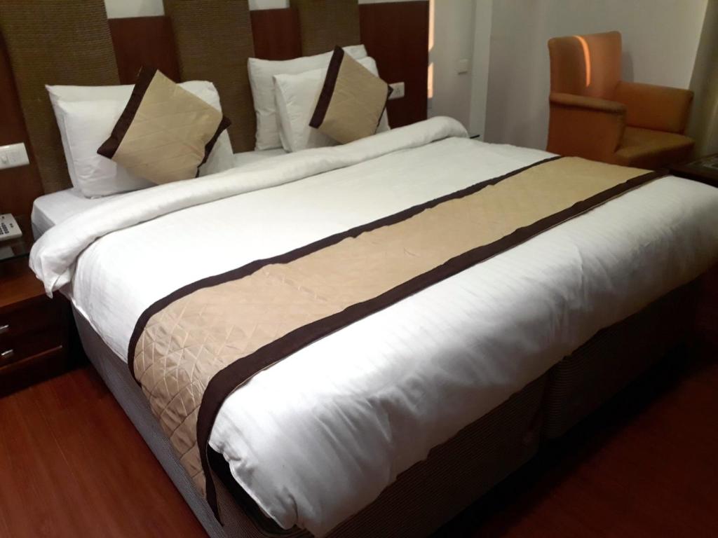 Airport Hotel Golden Bliss Near Delhi Airport في نيودلهي: سرير كبير في غرفة الفندق
