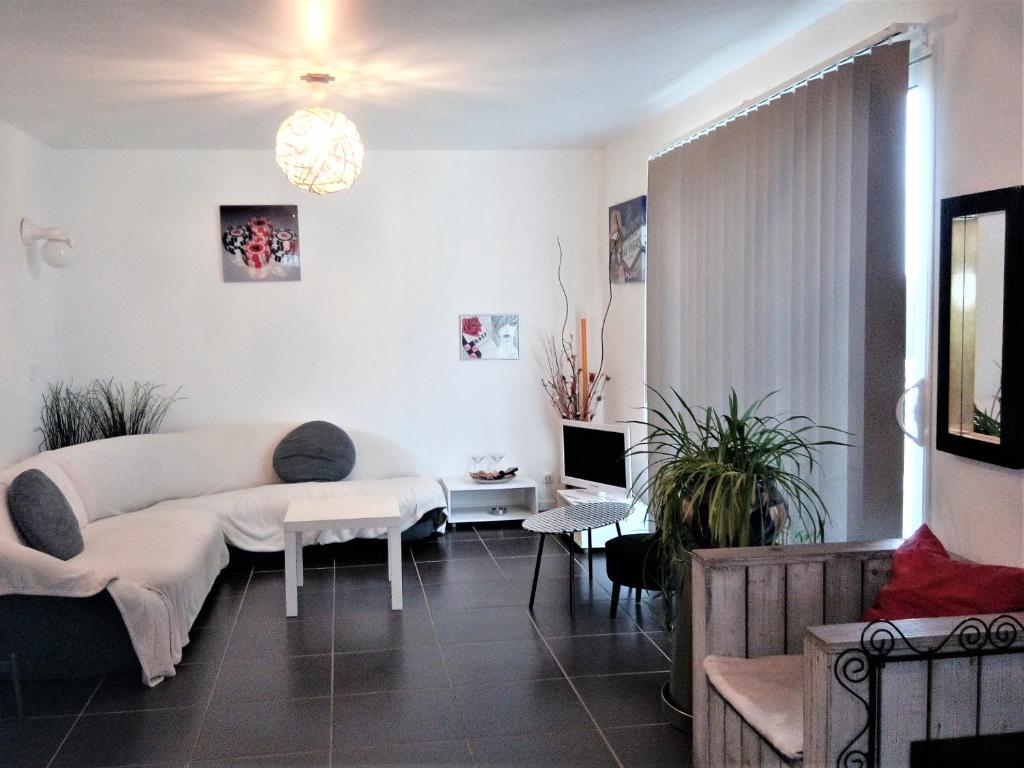 un soggiorno con un divano e una TV di Le Soleil en Gironde a Vrillant