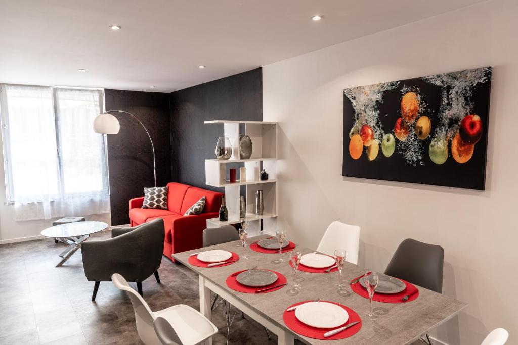 un salon avec une table et un canapé rouge dans l'établissement Champenois GARAGE PRIVATIF hypercentre 6 pers, à Épernay