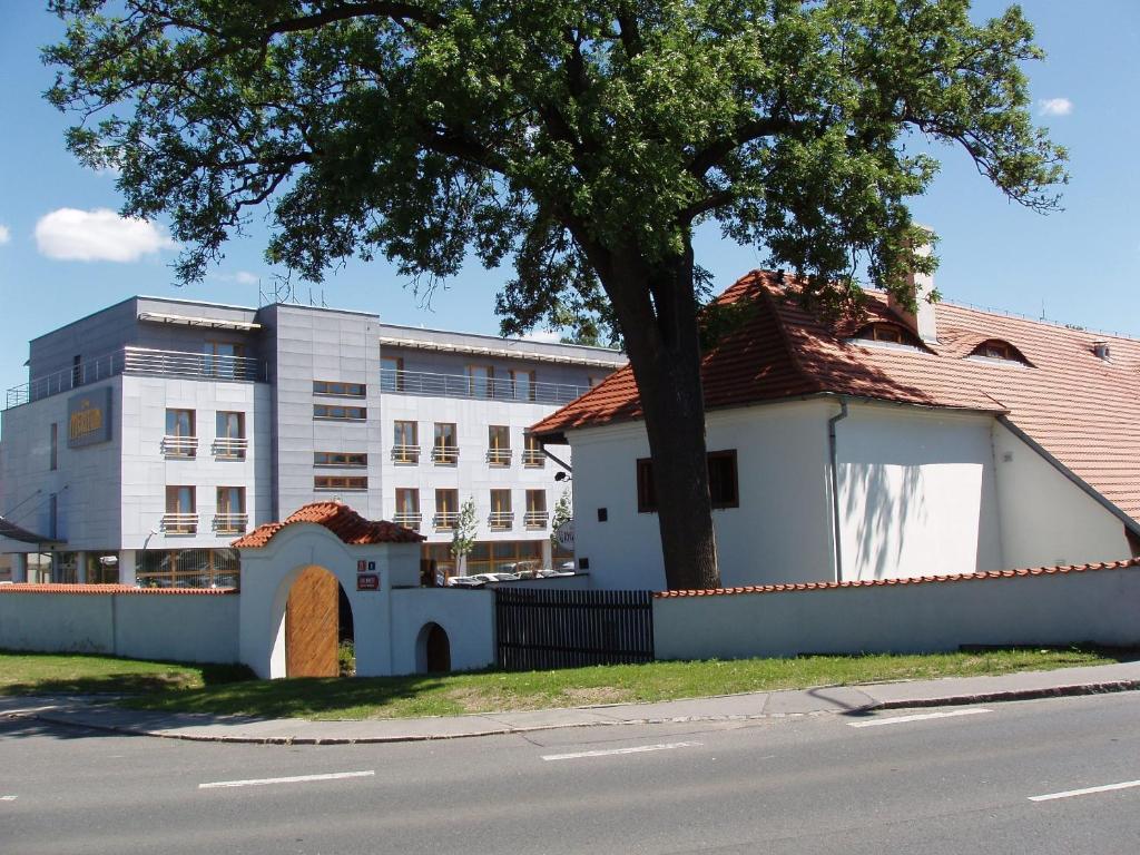 a building with a tree in front of a building at Hotel Meritum in Prague