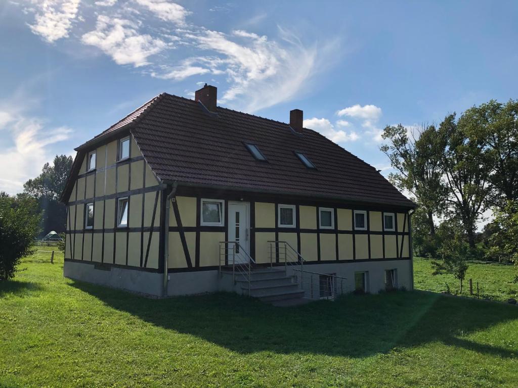 a large yellow and white house in a field at Ferienwohnung Bömitz in Rubkow