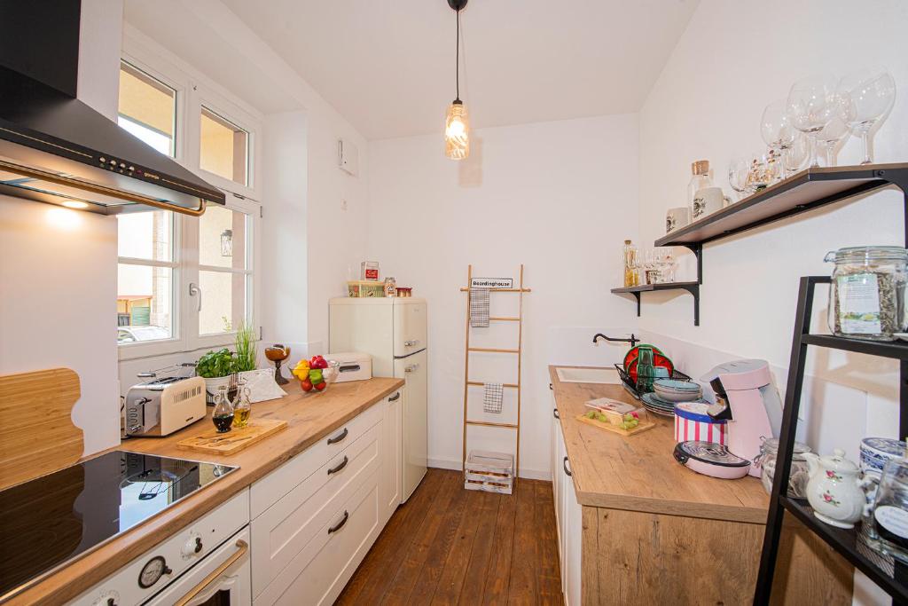 uma cozinha com balcões brancos e um frigorífico branco em Boardinghouse alte Spinnerei em Ofemburgo