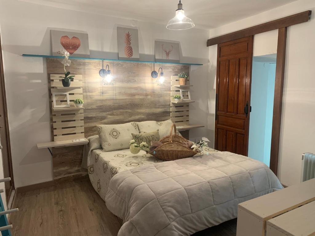 1 dormitorio con 1 cama y una pared con estanterías en El Refugio de Chloe, en Villar de Ves
