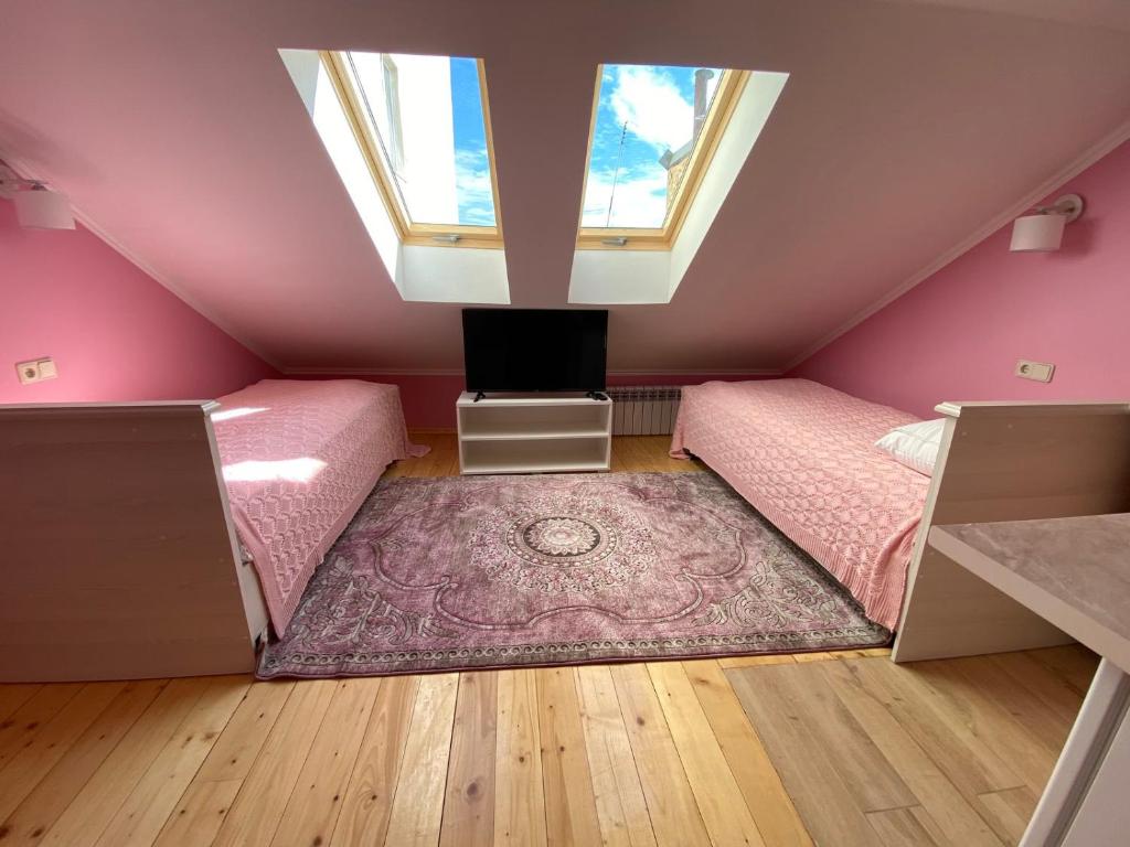 een roze kamer met een bed en een raam bij Аpartment for Lady in Tsjernivsi