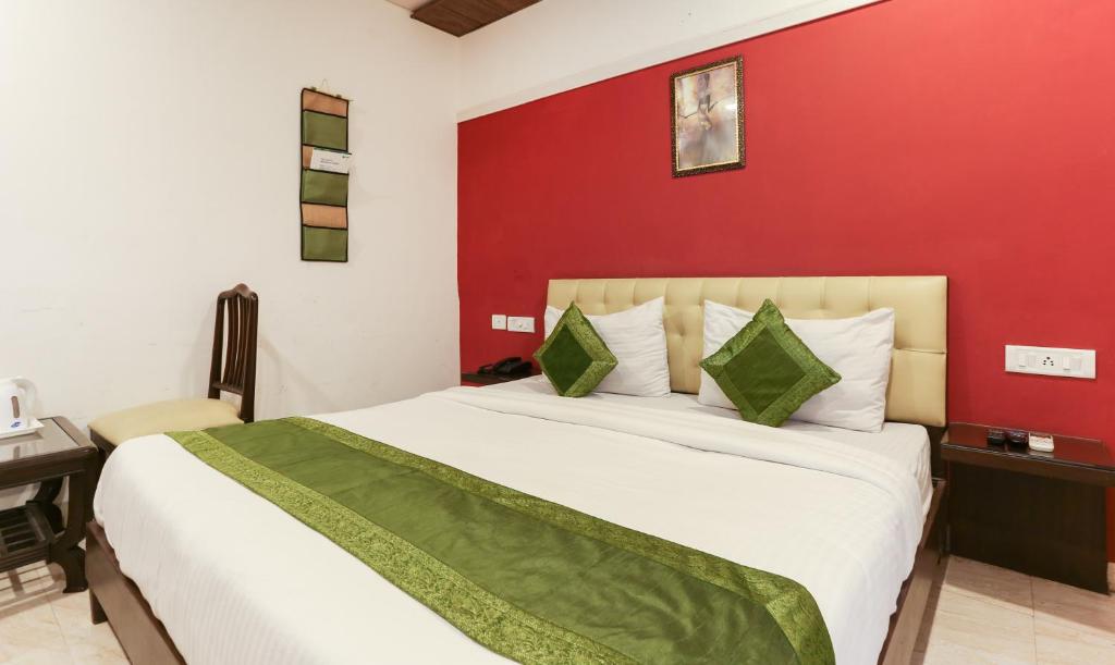 a bedroom with a large bed with a red wall at Hotel Seven- Center of City Chandigarh in Chandīgarh