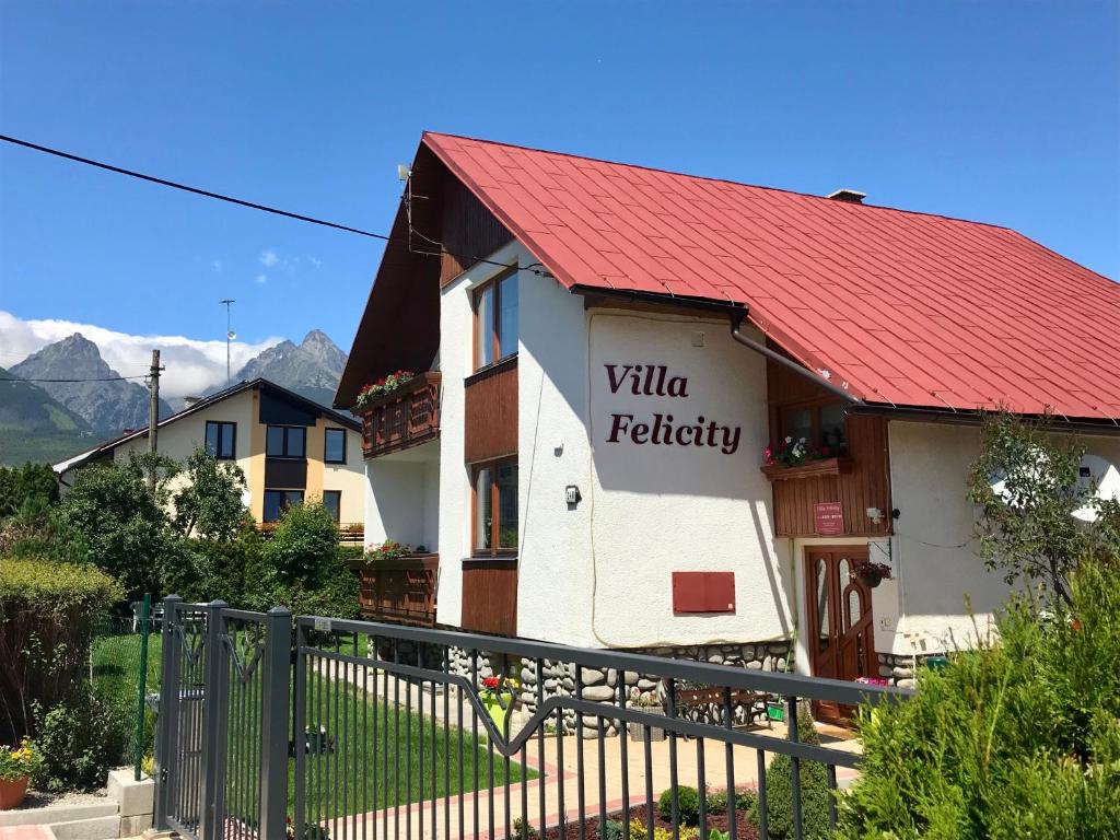 un edificio con techo rojo con un cartel. en Villa Felicity en Nová Lesná
