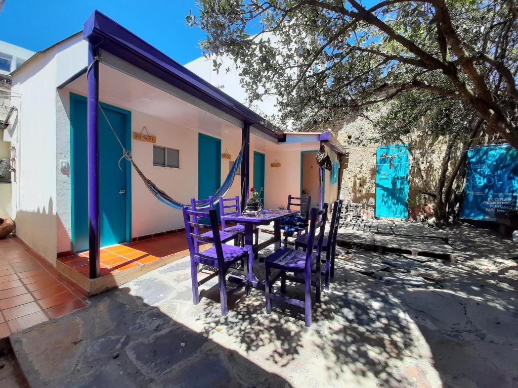 una mesa púrpura y sillas en el patio de una casa en Hostal Casa del Arbol, en Zipaquirá
