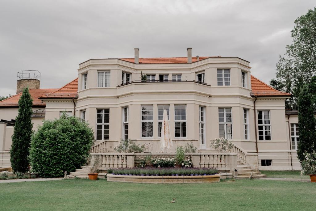 una gran casa blanca con techo rojo en Landhaus am Jungfernsee, en Potsdam